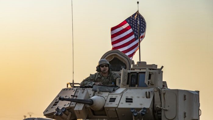 Un soldado estadounidense se sienta encima de un vehículo blindado de transporte de tropas Bradley mientras conduce cerca de la ciudad de Tal Tamr, en la nororiental provincia siria de Hasakeh, en la frontera con Turquía, el 10 de noviembre de 2019. (Delil Souleiman/AFP vía Getty Images)