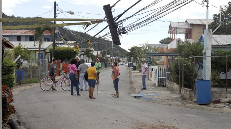 Unos residentes observan en la calle los daños causados por el temblor de magnitud 5,8 que se reportó este lunes a las 06.32 hora local (10.32 GMT) en la costa de Guánica, municipio del suroeste de Puerto Rico. Un nuevo terremoto de 6,6 grados se registró el 7 de enero de 2020 causan nuevos daños en la infraestructura y una muerte (EFE/ Thais Llorca)