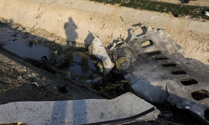 Detritos são vistos de um avião ucraniano que caiu enquanto autoridades trabalham no local em Shahedshahr, a sudoeste da capital Teerã, Irã, em 8 de janeiro de 2020 (Ebrahim Noroozi / AP)