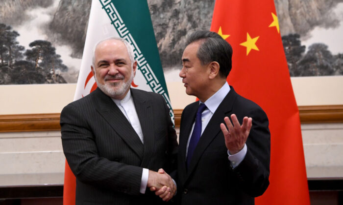 El ministro de Relaciones Exteriores de China, Wang Yi, le da la mano al ministro de Relaciones Exteriores de Irán, Mohammad Javad Zarif, durante una reunión en la casa de huéspedes del estado de Diaoyutai en Beijing, China, el 31 de diciembre de 2019. (Noel Celis-Pool/Getty Images)