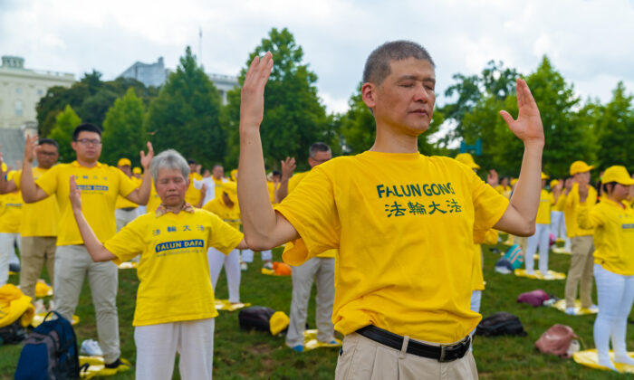 Los practicantes de Falun Gong realizan los ejercicios en un acto conmemorativo del 20 aniversario de la persecución a Falun Gong en China, en el jardín oeste de la colina del Capitolio el 18 de julio de 2019. (Mark Zou/La época de los tiempos)