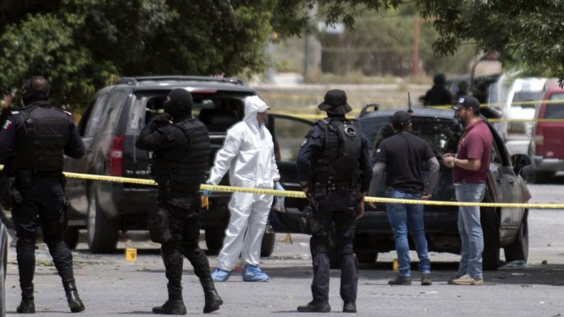 Investigadores mexicanos de la fiscalía y policías trabajan en la escena en la que un grupo armado se enfrentó a la policía y causó la muerte de nueve civiles y dos policías heridos en Saltillo, estado de Coahuila, el 27 de abril de 2019. (ALMA MONTIEL/AFP/Getty Images)