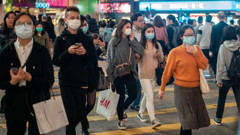 Los peatones usan máscaras faciales mientras caminan por un paso de peatones en el distrito de Causeway Bay el 23 de enero de 2020 en Hong Kong, China. (Anthony Kwan / Getty Images)