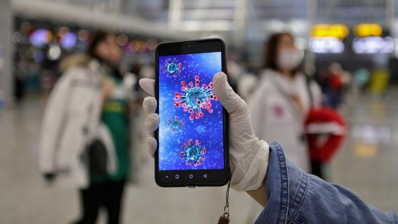 Un pasajero muestra una ilustración del coronavirus en su teléfono móvil en el aeropuerto de Guangzhou en Guangzhou, provincia de Guangdong, China, el 23 de enero de 2020. EFE/ EPA/ALEX PLAVEVSKI