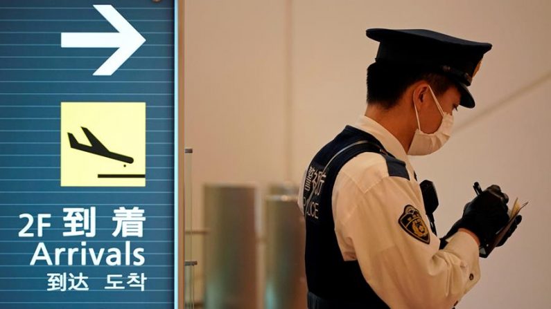 Un oficial de policía con una máscara toma notas en la sala de llegada del Aeropuerto Internacional de Tokio en Tokio, Japón, el 22 de enero de 2020. EFE / EPA / FRANCK ROBICHON