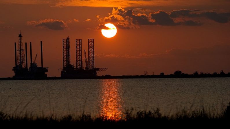 El sol se pone detrás de dos plataformas petroleras en construcción en Port Fourchon, Louisiana, el 14 de junio de 2010. (SAUL LOEB/AFP a través de Getty Images)