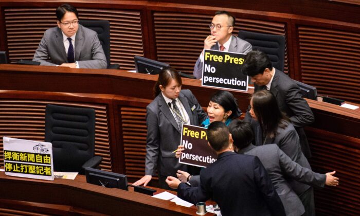 La legisladora prodemocracia de Hong Kong Claudia Mo (dcha.) es rodeada por personal de seguridad mientras grita "¡Prensa libre! ¡No a la persecución! mientras Carrie Lam (no aparece en la foto) llega para pronunciar su discurso en el Consejo Legislativo (Legco) de Hong Kong, el 10 de octubre de 2018. (Anthony Wallace/AFP vía Getty Images)