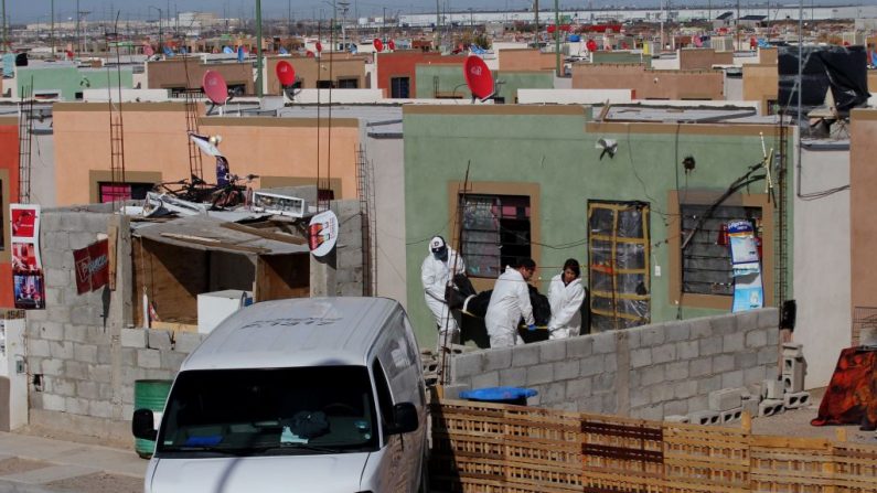 Expertos forenses retiran un cadáver de una casa donde cinco miembros de una familia fueron asesinados en Ciudad Juárez, estado de Chihuahua, el 16 de enero de 2019. (Herika Martinez/AFP vía Getty Images)