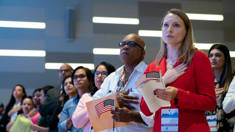 Los nuevos ciudadanos de EE.UU. se ponen de pie para el Juramento de Lealtad durante una ceremonia de naturalización dentro Museo del 11-S el 2 de julio de 2019 en la ciudad de Nueva York. (Drew Angerer/Getty Images)