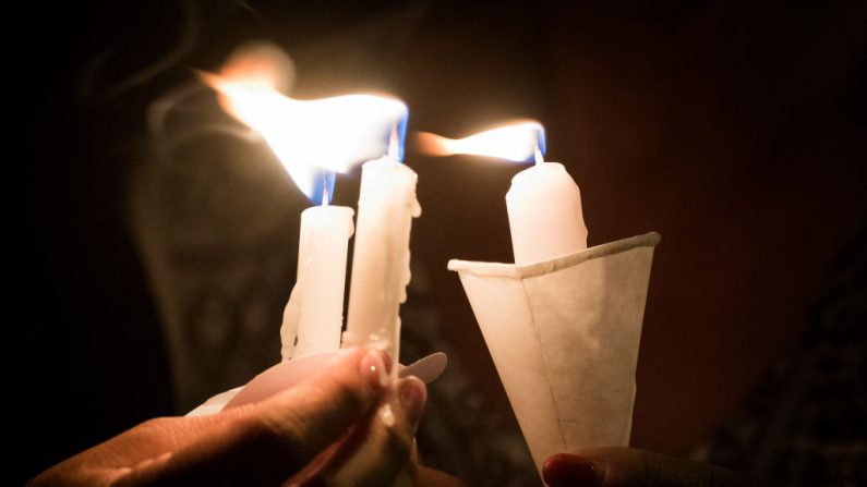 Las personas sostienen velas mientras rezan durante una vigilia con velas en una iglesia en EE.UU. Imagen de archivo. (MARK RALSTON / AFP / Getty Images)