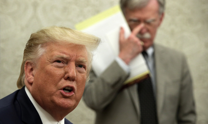El presidente Donald Trump habla con miembros de la prensa mientras el asesor de Seguridad Nacional John Bolton escucha en el Despacho Oval de la Casa Blanca el 20 de agosto de 2019. (Alex Wong/Getty Images)