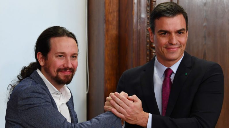 El presidente español, Pedro Sánchez (d) y el líder del partido de Podemos, Pablo Iglesias (i) después de firmar su acuerdo de gobierno de coalición en el Congreso de Madrid (España) el 30 de diciembre de 2019. (GABRIEL BOUYS / AFP a través de Getty Images)