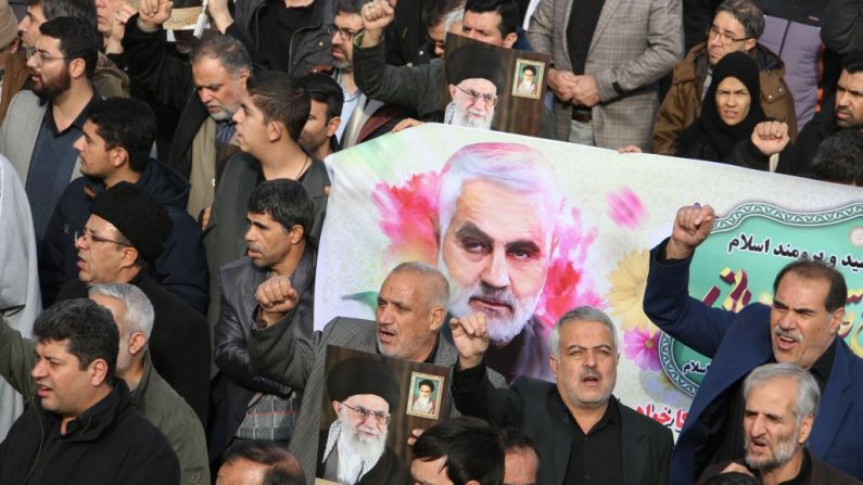 Los iraníes marchan con una ilustración del Mayor General de la Guardia Revolucionaria iraní, Qasem Soleimani, durante una manifestación en Teherán (Irán) el 3 de enero de 2020 contra el asesinato del máximo comandante en un ataque estadounidense en Bagdad. (Foto de ATTA KENARE / AFP a través de Getty Images) 