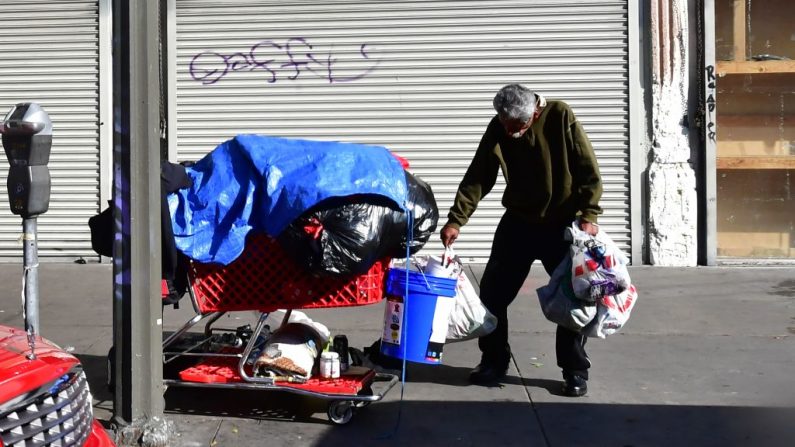 Un hombre sin hogar se para con un carrito de sus pertenencias en una calle de Los Ángeles, California, el 8 de enero de 2020. (Frederic J. Brown / AFP a través de Getty Images)