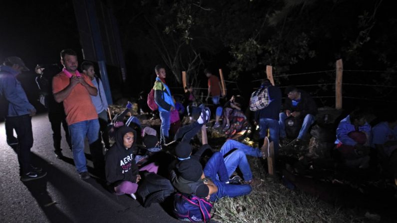 Los inmigrantes hondureños descansan al costado de una carretera en Esquipulas, departamento de Chiquimula, Guatemala, el 16 de enero de 2020 temprano en la mañana, después de cruzar la frontera desde Honduras en su camino a los Estados Unidos. (JOHAN ORDONEZ / AFP / Getty Images)