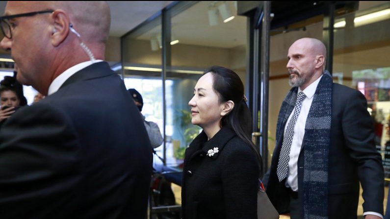 La directora financiera de Huawei Technologies, Meng Wanzhou, es acompañada por su personal de seguridad cuando sale de la corte durante un descanso para almorzar el primer día de su juicio de extradición el 20 de enero de 2020 en Vancouver, Canadá. (Jeff Vinnick/Getty Images)