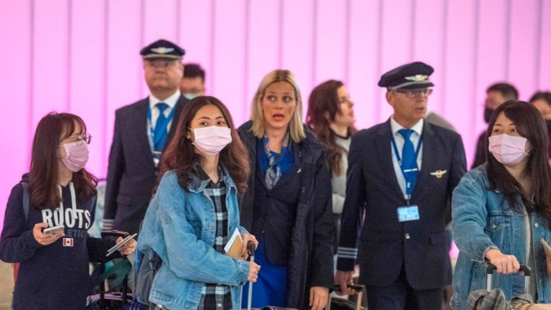 Los pasajeros llevan mascarillas para protegerse contra la propagación del Coronavirus cuando llegan al Aeropuerto Internacional de Los Ángeles, California (EE.UU.), el 22 de enero de 2020.  (MARK RALSTON/AFP vía Getty Images)