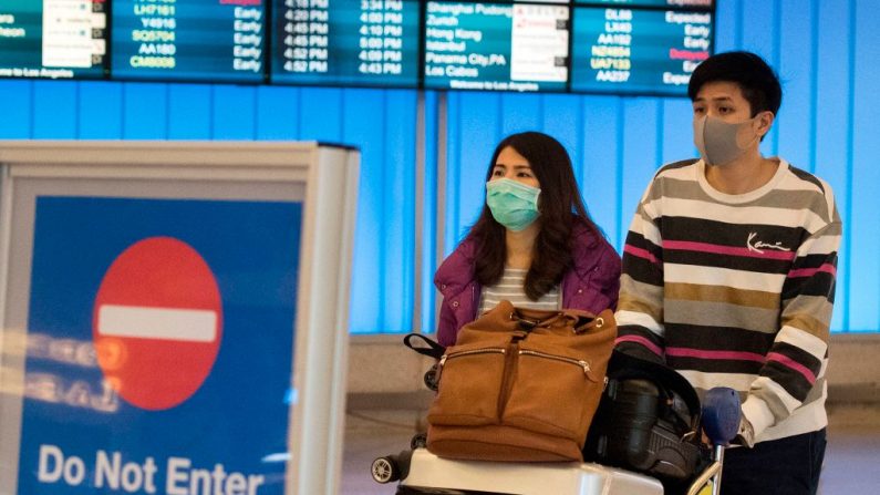 Pasajeros llevan máscaras para protegerse contra la propagación del Coronavirus al llegar al Aeropuerto Internacional de Los Ángeles, California, el 22 de enero de 2020.  (MARK RALSTON/AFP vía Getty Images)
