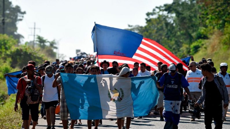Migrantes centroamericanos, que se dirigen en una caravana a los EE. UU., caminan con banderas guatemaltecas y estadounidenses desde Ciudad Hidalgo hasta Tapachula, estado de Chiapas, México, el 23 de enero de 2020. (ALFREDO ESTRELLA / AFP a través de Getty Images)