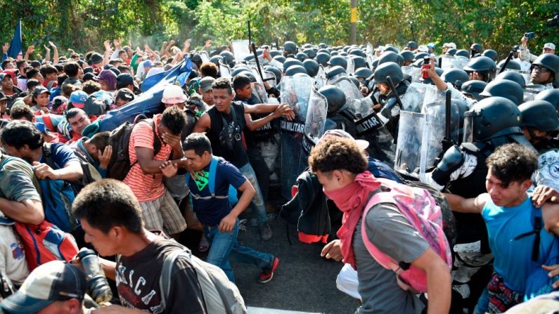 Miembros de la Guardia Nacional de México se enfrentan a migrantes centroamericanos, en su mayoría hondureños, que se dirigen en una caravana a Estados Unidos, en Ciudad Hidalgo, estado de Chiapas, México, el 23 de enero de 2020. (ALFREDO ESTRELLA / AFP a través de Getty Images)