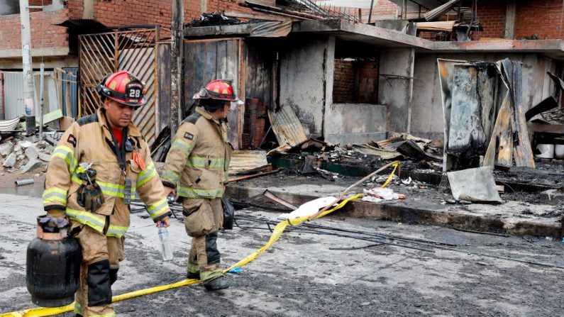 En una foto de archivo, los bomberos pasan por casas destruidas después de la explosión de un camión cisterna de gas en Lima, Perú, el 23 de enero de 2020. (STR / STR / AFP vía Getty Images)