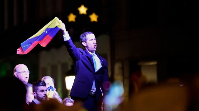 El presidente encargado, Juan Guaido, sostiene una bandera venezolana mientras pronuncia un discurso durante una manifestación de venezolanos que viven en Madrid en apoyo de la oposición venezolana en la Plaza de la Puerta del Sol en Madrid el 25 de enero de 2020. (JAVIER SORIANO / AFP / Getty Images)
