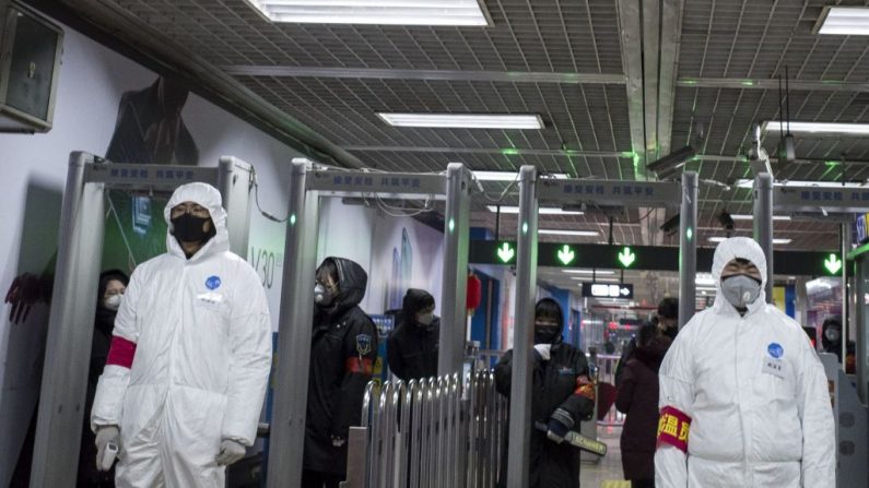 Personal de seguridad lleva ropa protectora para ayudar a detener la propagación de un virus mortal que comenzó en Wuhan, se encuentra en una estación de metro en Beijing el 26 de enero de 2020. (NOEL CELIS/AFP via Getty Images)