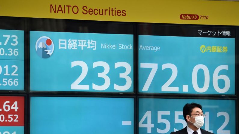 Un peatón se para frente a una tabla de anuncios que muestra los números de la mañana en el índice Nikkei 225 de la Bolsa de Valores de Tokio el 27 de enero de 2020. - El índice Nikkei clave de Tokio cayó más del 2% en la apertura del 27 de enero por las preocupaciones sobre el posible impacto de un nuevo coronavirus que ha matado a 80 personas en China. (KAZUHIRO NOGI/AFP vía Getty Images)