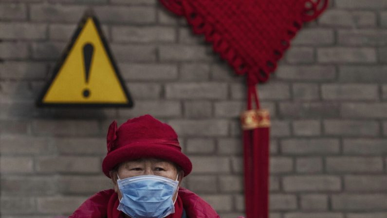 Una visitante china lleva una máscara protectora mientras recorría los terrenos del Templo del Cielo, que permaneció abierto durante el feriado del Año Nuevo Chino en Beijing, China, el 27 de enero de 2020. (Kevin Frayer/Getty Images)