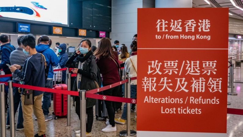 Viajeros con máscaras protectoras esperan en fila para el reembolso de sus boletos en la Estación de Tren de Alta Velocidad de Hong Kong el 29 de enero de 2020 en Hong Kong, China. El gobierno de Hong Kong negará la entrada a los viajeros que hayan estado en la provincia de Hubei, excepto a los residentes locales, en respuesta a la restricción de los viajes internacionales y el cruce de fronteras para detener la propagación del virus. (Foto de Anthony Kwan/Getty Images)