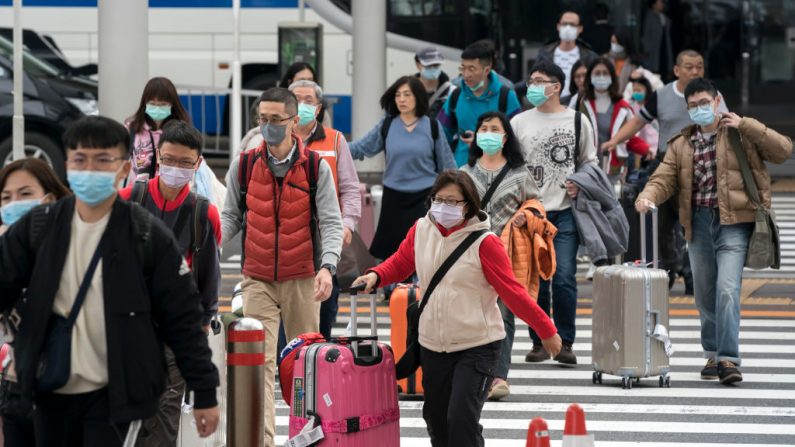 Un grupo de turistas chinos camina fuera del vestíbulo de llegada al aeropuerto de Narita el 24 de enero de 2020 en Narita, Japón. (Tomohiro Ohsumi / Getty Images)