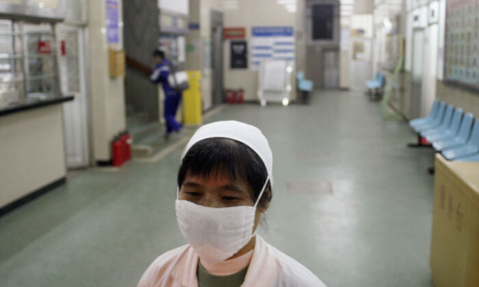 Una enfermera con una máscara facial camina en un pasillo de un hospital en Guangzhou, China, el 13 de enero de 2004. (Getty Images)