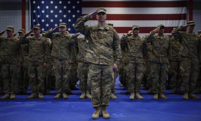 Soldados del Ejército de los Estados Unidos saludan durante el himno nacional (la bandera tachonada de estrellas) durante una ceremonia de regreso a casa en el Centro de Aptitud Física Natcher en Fort Knox, Kentucky, el 27 de febrero de 2014. (Luke Sharrett/Getty Images)
