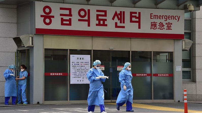 Trabajadores médicos surcoreanos con equipo de protección caminan hacia un centro clínico separado para atender a un brote epidémico de enfermedad respiratoria del coronavirus MERS en el Hospital Universitario de Konkuk en Seúl el 24 de junio de 2015. (JUNG YEON-JE/AFP a través de Getty Images)