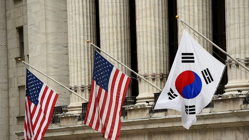 La bandera de Corea del Sur (Der.) ondea con banderas de EE.UU. fuera de la Bolsa de Nueva York antes de que el embajador de Corea del Sur en los EE.UU. Ahn Ho-Young tocara la campana de apertura en la Bolsa de Nueva York el 13 de mayo de 2014 en Nueva York. FOTOGRAFÍA AFP/Stan HONDA (El crédito de la foto debe leerse STAN HONDA/AFP a través de Getty Images)