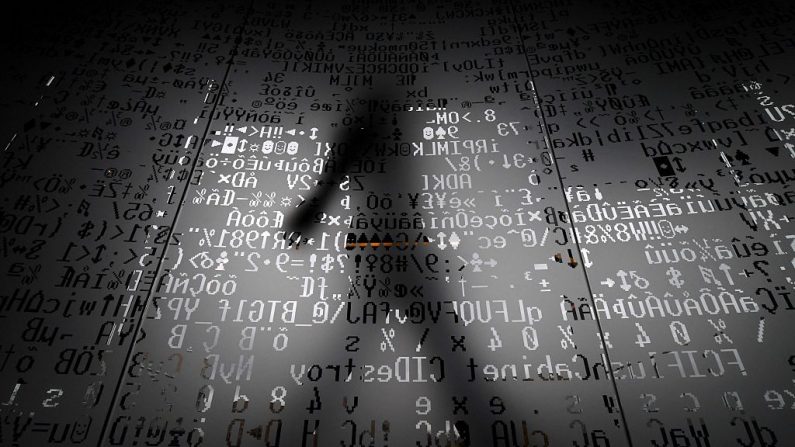 Empleado caminando detrás de una pared de cristal con símbolos de codificación de máquinas en la sede de un gigante de la seguridad en Internet, el 17 de Octubre del 2016. (KIRILL KUDRYAVTSEV/AFP a través de Getty Images)