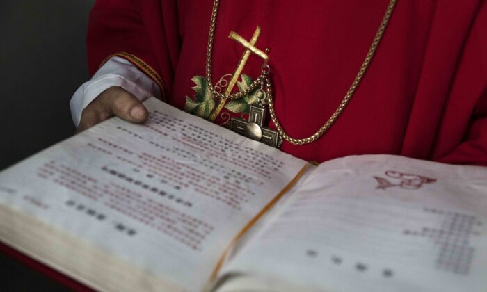 Un diácono católico chino sostiene una biblia en la Misa del Domingo de Ramos durante la Semana Santa de Pascua en una iglesia "clandestina" o "no oficial" cerca de Shijiazhuang, provincia de Hebei, China, el 9 de abril de 2017. (Kevin Frayer/Getty Images)