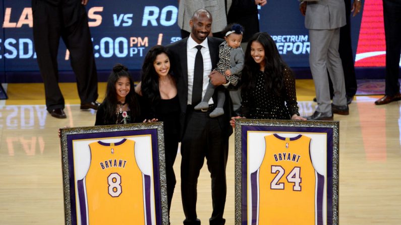 Kobe Bryant posa con su familia en el medio tiempo después de que tanto su camiseta número 8 como la número 24 de los Lakers de Los Ángeles se retiren en el Staples Center el 18 de diciembre de 2017 en Los Ángeles, California.  (Fotografía de Maxx Wolfson/Getty Images)