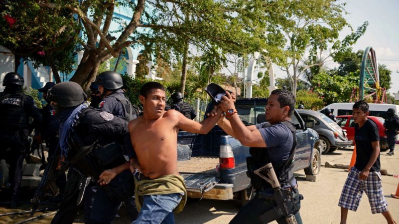 Un miembro del Coordinador Regional de Autoridades Comunitarias (CRAC) es arrestado por policías del estado de Guerrero después de una serie de enfrentamientos que han dejado al menos 11 personas muertas en la aldea de La Concepción, municipio de Acapulco, en el estado de Guerrero, México, el 7 de enero de 2018. Al menos 11 personas murieron y 30 fueron arrestadas durante enfrentamientos armados entre civiles, guardias comunitarios y policías en una zona rural de Acapulco, en el sur de México, confirmó el gobierno de Guerrero. (FRANCISCO ROBLES/AFP vía Getty Images)