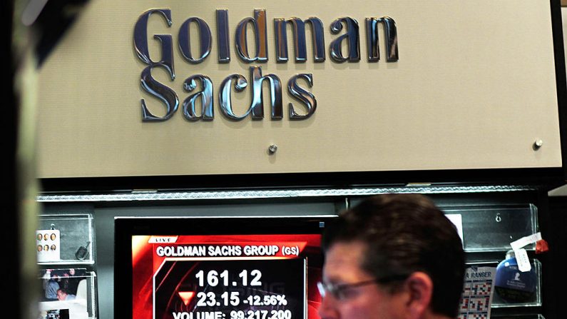 Un profesional de las finanzas trabaja en el stand de Goldman Sachs en la Bolsa de Valores de Nueva York, mientras que un reportaje televisivo se transmite sobre la baja del precio de las acciones de la empresa, el 16 de abril de 2010 en Nueva York. (Chris Hondros/Getty Images)