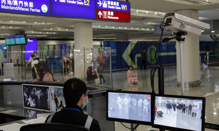 Um oficial de vigilância da saúde monitora os passageiros que chegam ao aeroporto internacional de Hong Kong em Hong Kong, em 4 de janeiro de 2020 (AP Photo / Andy Wong)