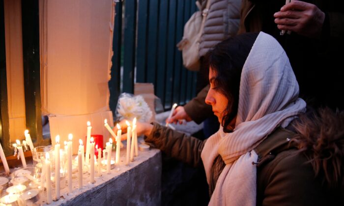 Una mujer iraní enciende velas para las víctimas del Boeing 737 de Ukraine International Airlines durante una concentración frente a la Universidad Amirkabir en la capital Teherán, el 11 de enero de 2020. (AFP vía Getty Images)