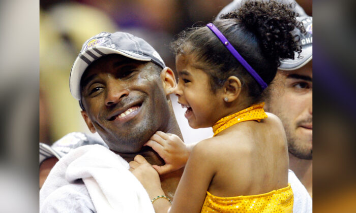 Kobe Bryant, #24 de los Lakers de Los Ángeles, sostiene a su hija Gianna después de que los Lakers derrotaran a los Orlando Magic por 99-86 en el quinto juego de las finales de la NBA de 2009 en el Amway Arena de Orlando, Florida, el 14 de junio de 2009. (Ronald Martinez/Getty Images)