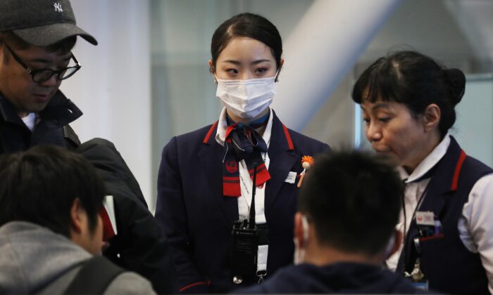 Una trabajadora de Japan Airlines (Centro) usa máscara facial mientras trabaja dentro de una terminal del Aeropuerto Internacional de Los Ángeles (LAX) el 23 de enero de 2020. (Mario Tama/Getty Images)