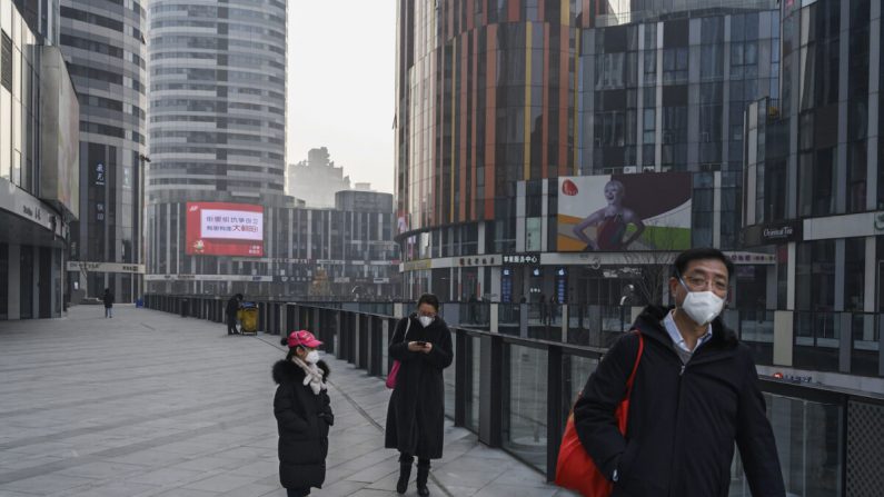 Una familia china lleva mascarillas protectoras mientras camina por una zona de compras vacía que normalmente estaría concurrida durante la festividad del Año Nuevo y el Festival de Primavera de China en Beijing, China, el 28 de enero de 2020. (Kevin Frayer/Getty Images)