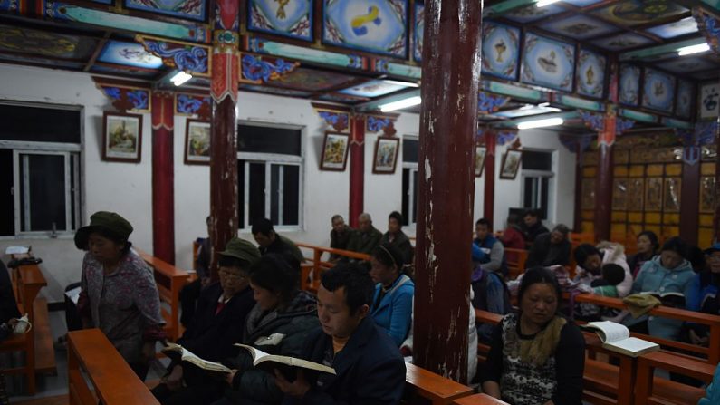Fotografía de archivo tomada el 18 de marzo de 2015 que muestra a los feligreses durante una reunión religiosa en la Iglesia Católica de Nidadang, cerca de Bingzhongluo, una zona tibetana en el suroeste de la provincia de Yunnan en China. El catolicismo fue introducido en la región hace más de cien años por los misioneros franceses. A pesar de décadas de persecución y el cierre de iglesias bajo el líder comunista Mao Zedong, los tibetanos católicos y otras minorías han mantenido fuertes creencias religiosas. (GREG BAKER/AFP a través de Getty Images)