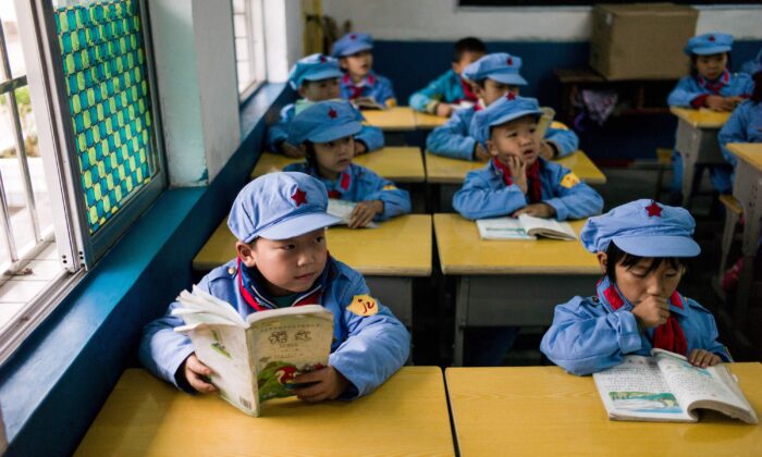 Varios alumnos leen en un aula de la escuela primaria del "Ejército Rojo" de Yang Dezhi en Wenshui, en el Condado de Xishui de la provincia de Guizhou (China), el 7 de noviembre de 2016. (Fred Dufour/AFP via Getty Images)