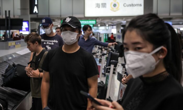 Viajeros que usan mascarillas como medida de precaución para protegerse contra el brote de coronavirus, en el Aeropuerto Internacional de Hong Kong, el 23 de enero de 2020. (Vivek Prakash / AFP a través de Getty Images)