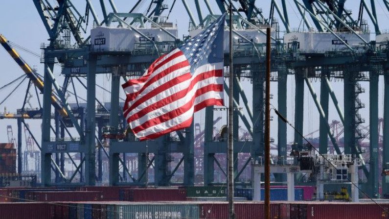 Bandeira dos Estados Unidos ondula sobre contêineres chineses que foram descarregados no porto de Long Beach, no Condado de Los Angeles, em 29 de setembro de 2018 (Mark Ralston / AFP / Getty Images)