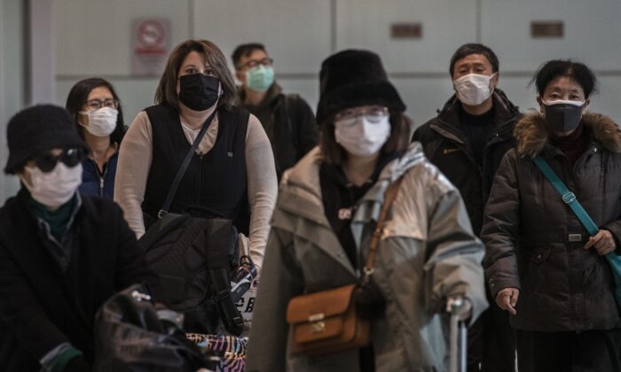 Los pasajeros llevan máscaras protectoras al llegar al aeropuerto de la capital de Beijing, China, el 30 de enero de 2020. (Kevin Frayer/Getty Images)